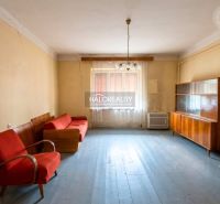Living room in a family house with older furniture and wooden floor decor.