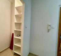 The 1-room apartment features built-in shelves and a door with an intercom.