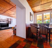 Interior of a family house with a dining room, living room, and wooden decor flooring.
