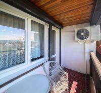 A balcony of a family house in Rimavská Sobota with rattan furniture and air conditioning.