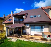 A family house in Rimavská Sobota with a sloped roof and a grassy garden.