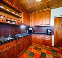 A kitchen in a family house with wooden decor and a black countertop.