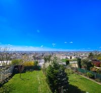 A family house in Rimavská Sobota with a view of the surrounding countryside and a green garden.