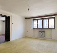 A furnished room in the renovation phase, real estate - residential, light penetrates through large windows.