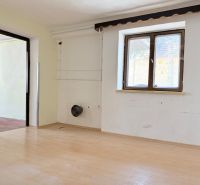 A room with a wooden floor decor, sunlight through the window, empty walls.