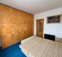 Bedroom in a 3-room apartment with a large wardrobe and a picture on the wall.