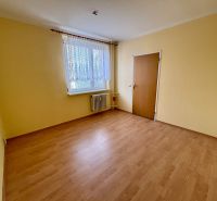 A room in a 3-room apartment with a wooden decor floor and a radiator under the window.