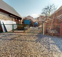 A courtyard with a gravel surface and a gate in the Recreational Grounds in Hybe.