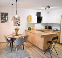 A kitchen with a dining area and a wooden decor floor in a 2-room apartment.