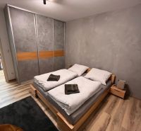 Bedroom with a bed and wooden decor flooring in a 2-room apartment.