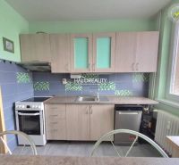 Kitchen in a 3-room apartment with a wooden decor, light cabinets, dishwasher, stove.