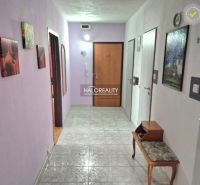A hallway in a 3-room apartment with tiles, a bench, and wall decorations.
