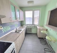 A kitchen with tiles and bar stools in a 3-room apartment.