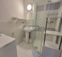 A bathroom with a shower, sink, and washing machine in a 3-room apartment.