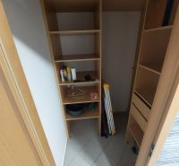 Wardrobe with shelves and various items in a 2-room apartment.