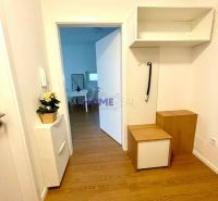 A hallway in a 3-room apartment with a wooden decor floor and white furniture.