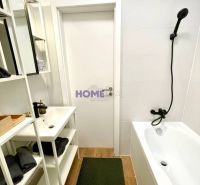 A bathroom in a 3-room apartment with a bathtub, a white sink, and a floor with a wooden decor.