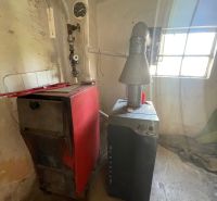 Boiler room in a family house with a boiler and chimney system.