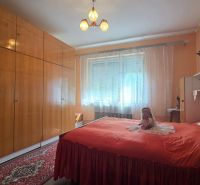 Bedroom with a large wardrobe and a red bed in a family house.