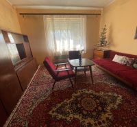Living room with a carpet, comfortable armchairs, and a sofa in a family house.