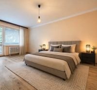Bedroom with wood-patterned flooring in a 2-room apartment, elegant soft lighting.