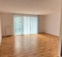 A room with a wooden decor floor and a kitchen nook in a family house.