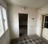 Entrance hallway of a family house with black and white patterned tiles.