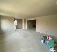 The interior of a family house during renovation, with white plaster and buckets of materials.