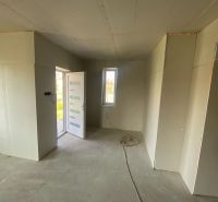 Interior of a family house with white doors and concrete floor.