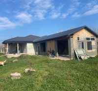A family house in Encs with a black roof, under construction, surrounded by a grassy plot.