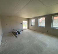 The interior of a family house with a concrete floor and unfinished walls.