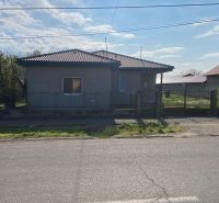 A family house in Encs with a garden and fencing, located by the road.