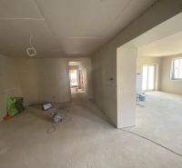 The interior of a family house with unfinished surface treatments and a concrete floor.