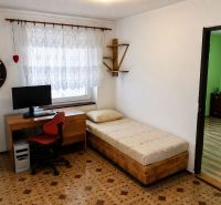 A room with a computer and a bed, a floor with a wooden decor, a 3-room apartment.