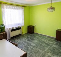 A green-painted room with an aquarium, curtains, and a chandelier in a 3-room apartment.