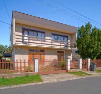 A family house in Veľký Lapáš with a garden and a wooden fence.