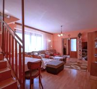 Interior of a family house with a fireplace, wooden decor flooring, and a staircase.