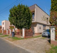 A family house in Veľký Lapáš with a front garden, a car, and a modified fence.