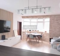 Living room in a two-room apartment with a television and a corner window, floor with wood decor.