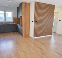 A kitchen in a family house with a wooden decor floor and wooden paneling.