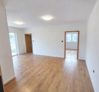 A room in a family house with white walls and a wooden decor floor.