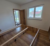 A room in a family house with a bed frame and a wooden decor floor.