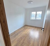 A room in a family house with a floor featuring a wooden decor and a window.