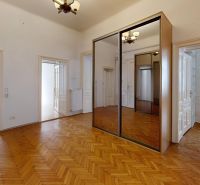 Interior of a 4-room apartment with a wooden decor floor and a large built-in wardrobe.