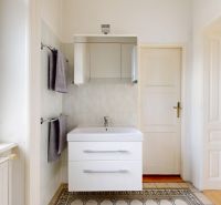 Bathroom in a 4-room apartment with a cabinet, mirror, and radiator by the window.