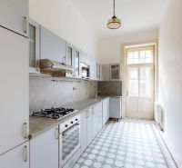 A kitchen in a 4-room apartment with white cabinets and patterned tiles.