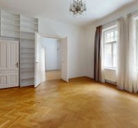 A room with built-in shelves, a chandelier, and a wooden decor floor in a four-room apartment.