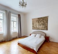 Bedroom in a 4-room apartment with a double bed, large windows, and a wooden decor floor.