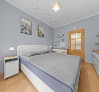 Bedroom in a 3-room apartment with wall decorations and a wooden decor floor.