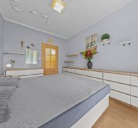 Bedroom in a 3-room apartment with a bed, furniture, and decorations, floor with wooden decor.